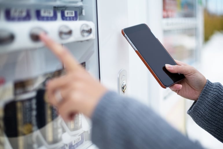 Woman use of soft drink vending system paying by cellphone.jpeg